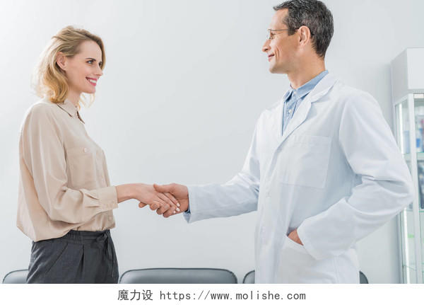 男性医生和女性病人握手在现代牙科诊所合作团结握手商务人士合作握手口腔牙齿